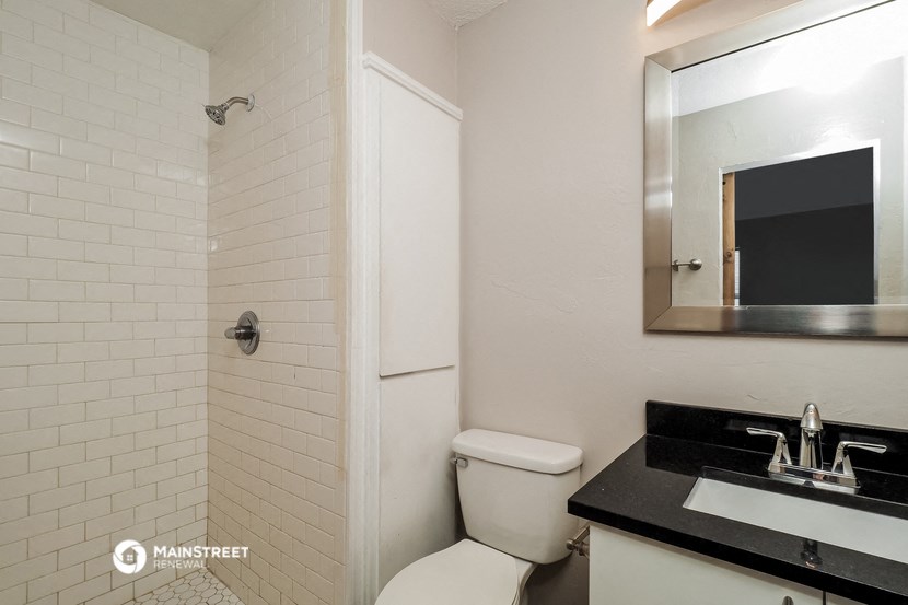 a bathroom with a toilet and a sink and a mirror