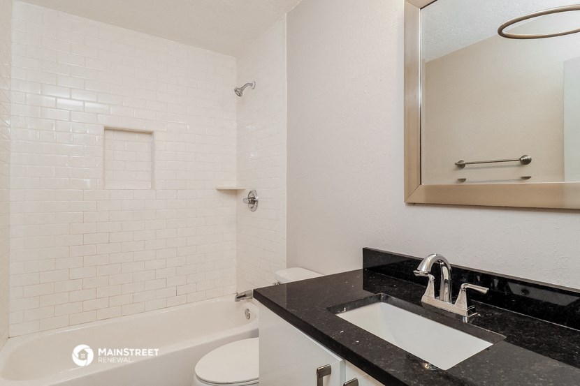 a bathroom with a sink and a tub and a mirror