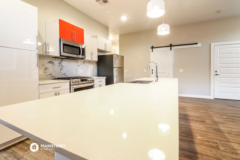 a large white kitchen with a white counter top and a stainless steel
