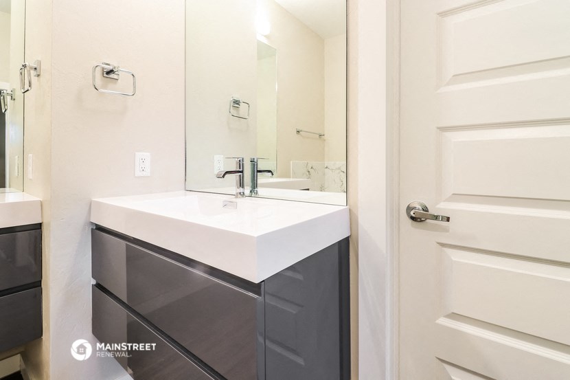a white bathroom with a sink and a mirror