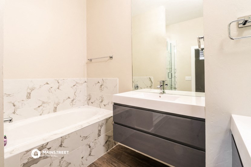 a bathroom with a tub and a sink and a mirror