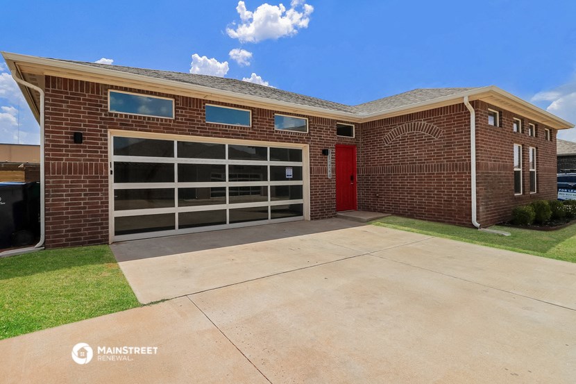 the front of a brick school building with a red door