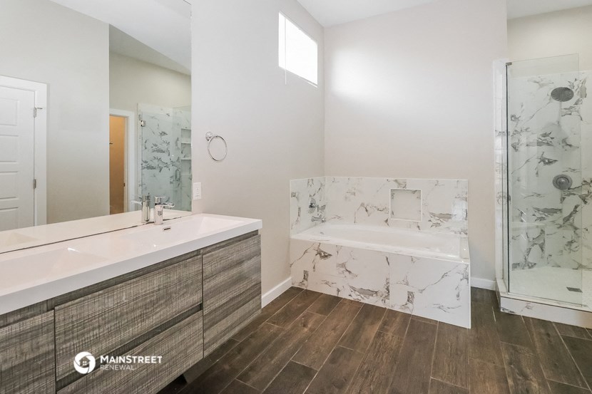 a bathroom with a large tub and a sink and a mirror