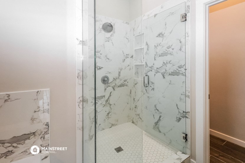 a marble shower in a bathroom with a glass door