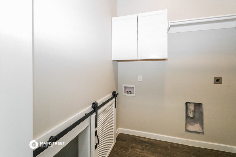 a stairwell in a home with white walls and white cabinets and white railings