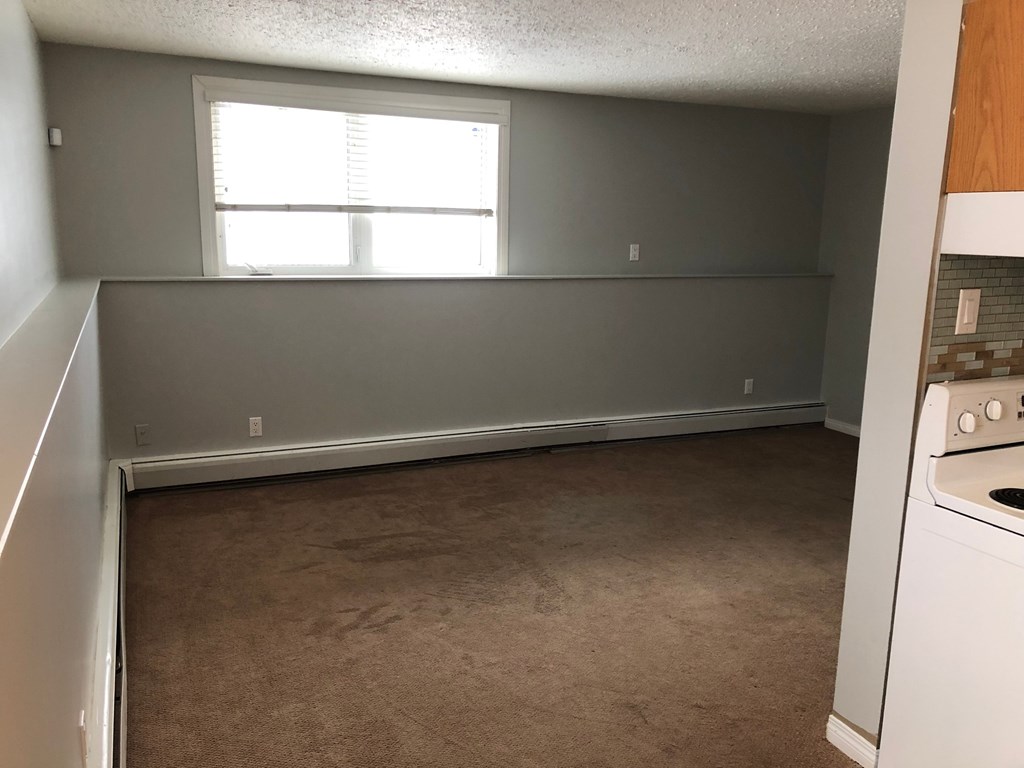 an empty kitchen with a stove and a window