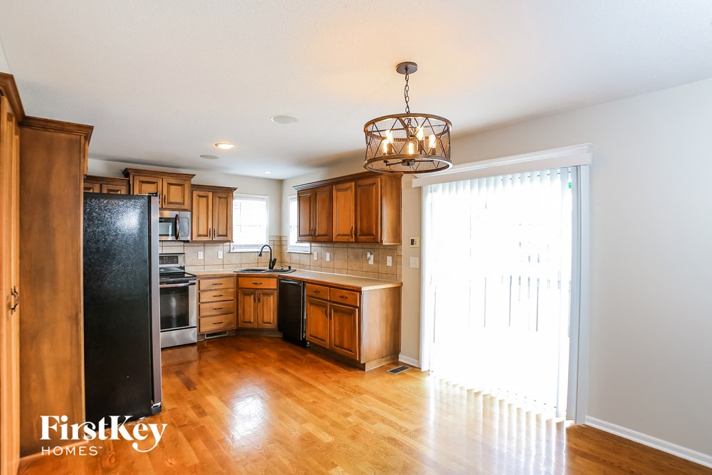 a kitchen with wood floors and wooden cabinets