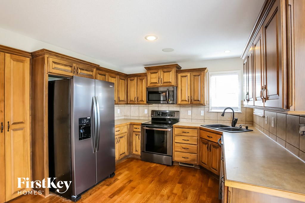 a kitchen with wooden cabinets and stainless steel appliances