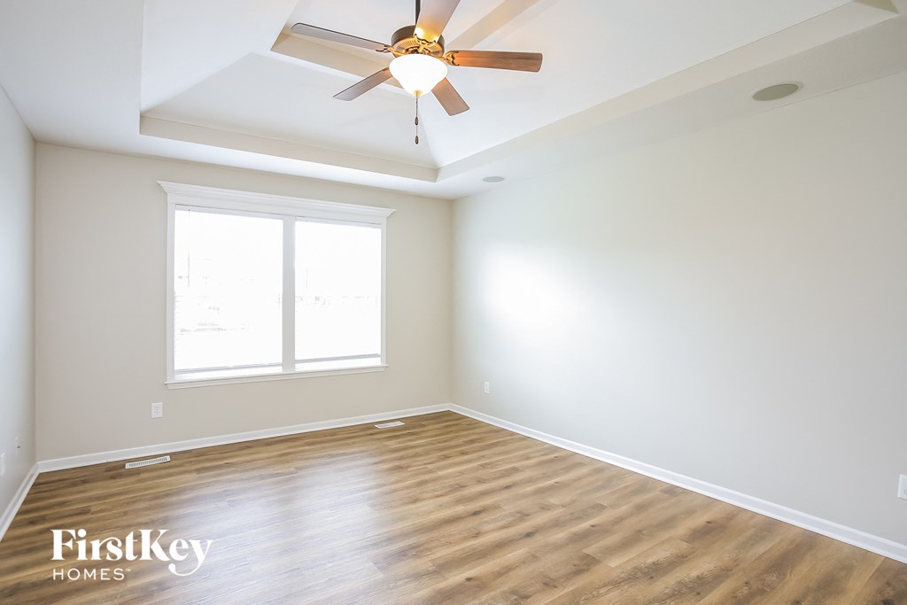 a empty room with a ceiling fan and a window