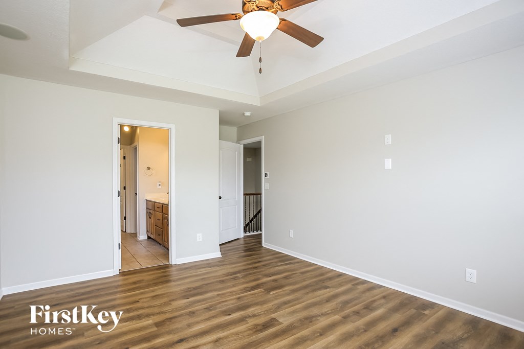 a living room with white walls and a ceiling fan