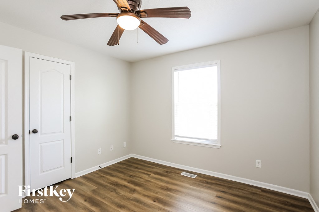 a bedroom with a ceiling fan and a door