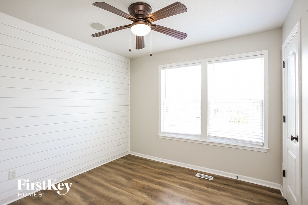 a bedroom with a ceiling fan and a window