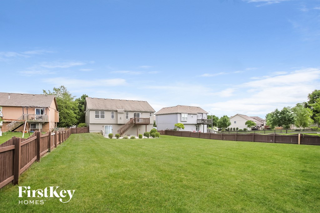 a fisheye view of a fenced in yard with houses behind it