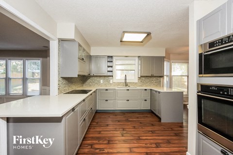 A kitchen with wooden floors and a FirstKey Homes sign.