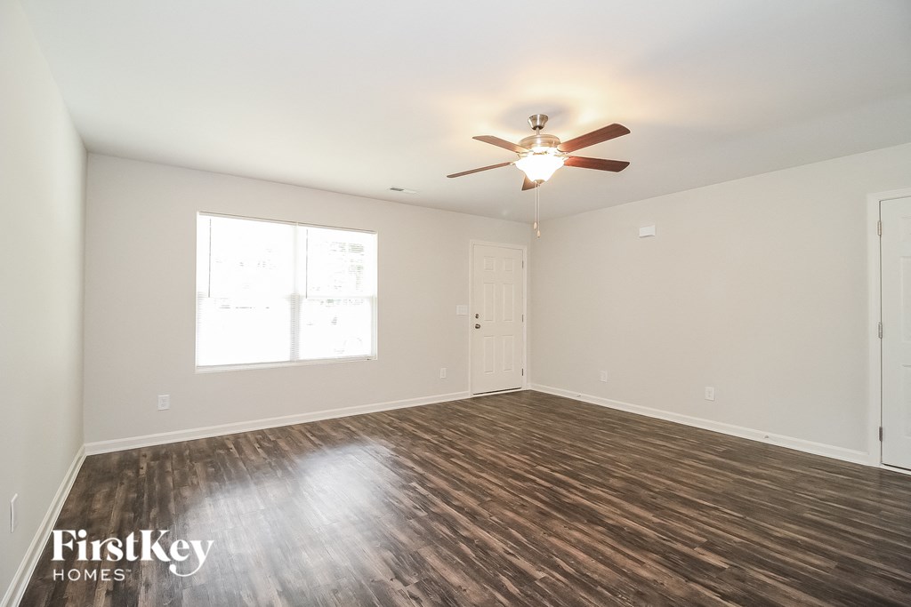 the living room of an empty house with a ceiling fan