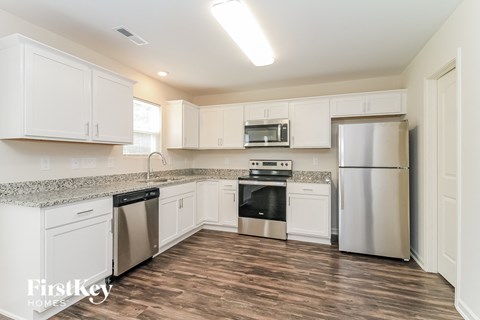 a renovated kitchen with white cabinets and stainless steel appliances