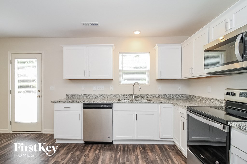 a kitchen with white cabinets and stainless steel appliances