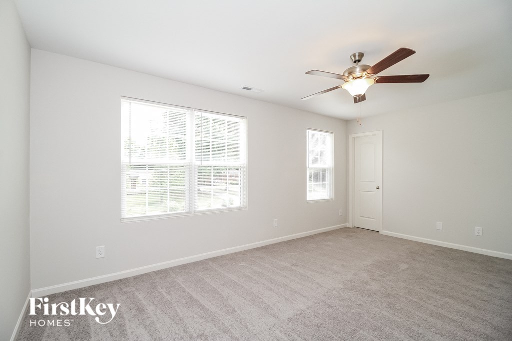 a living room with a ceiling fan and a large window