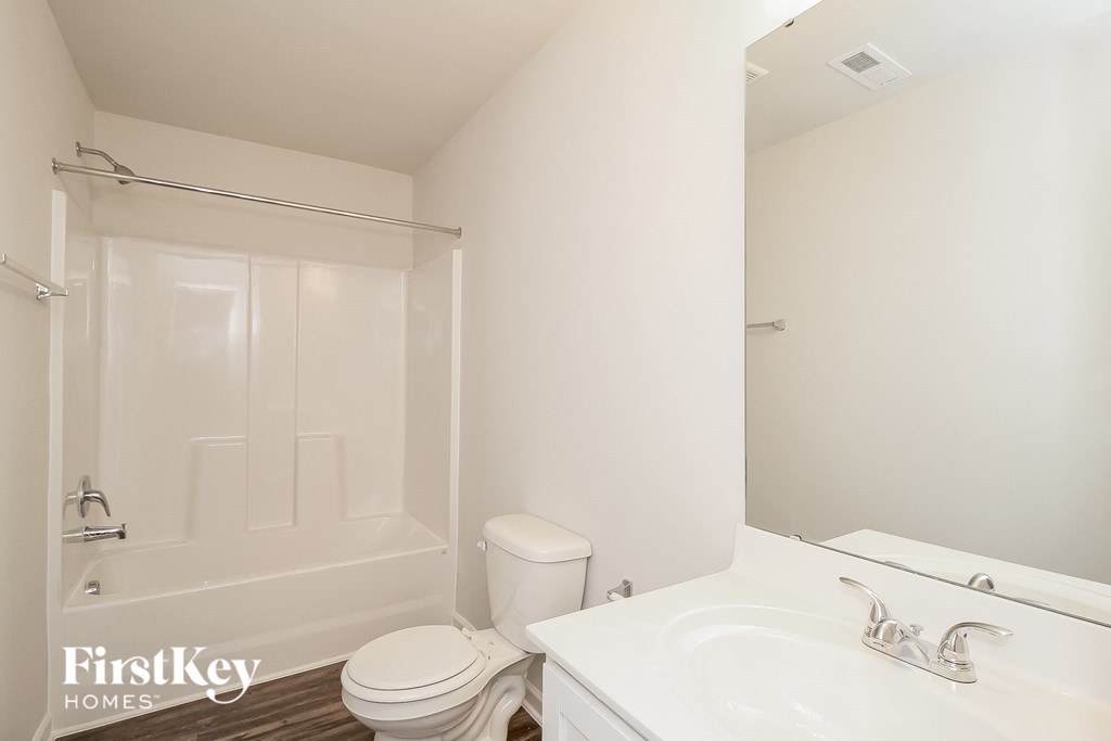 a bathroom with a white sink and a toilet and a shower