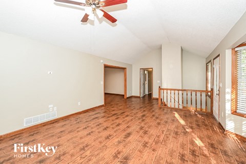 a living room with a wooden floor and a ceiling fan