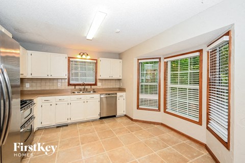 a large kitchen with white cabinets and a sink