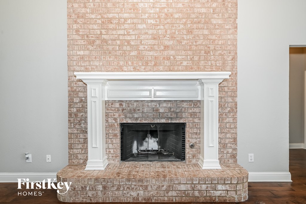 a brick fireplace with a white mantel in a living room