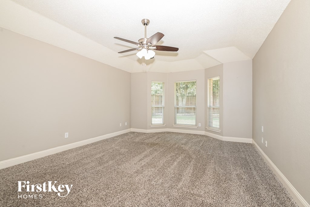 the living room of an empty house with a ceiling fan