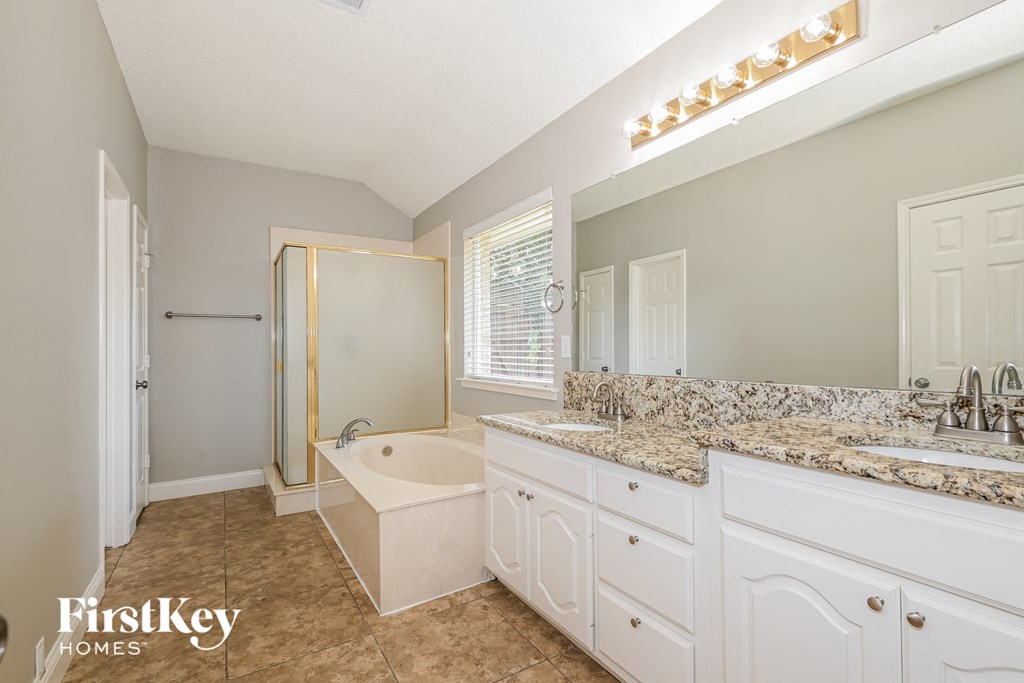 a bathroom with a tub and a sink and a mirror