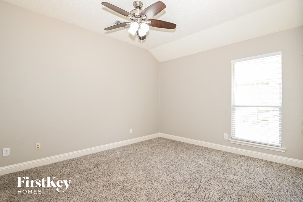 a empty room with a ceiling fan and a window