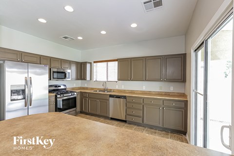 A kitchen with a refrigerator, stove, and oven.