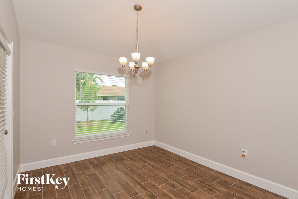 the spacious living room with wood flooring and a large window
