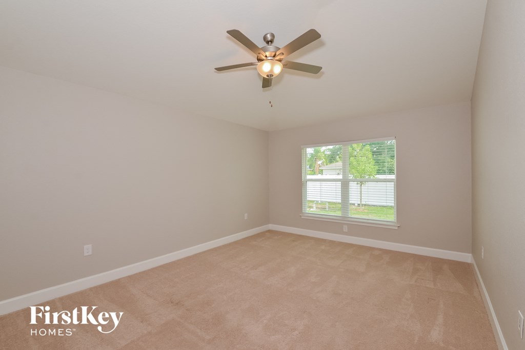 a bedroom with a ceiling fan and a window