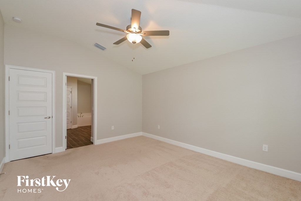 a bedroom with white carpet and a ceiling fan