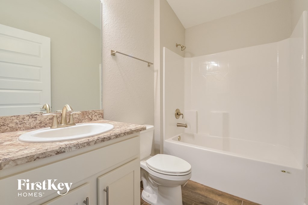a white bathroom with a sink toilet and shower