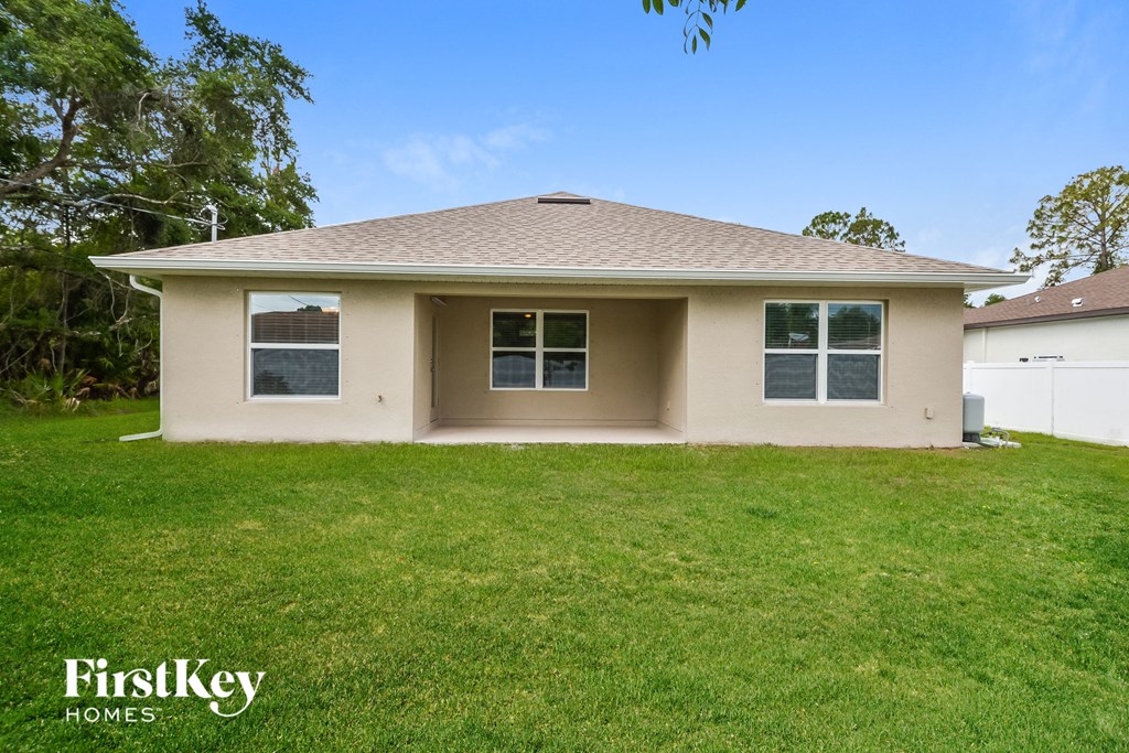 a beige house with a lawn and a garage