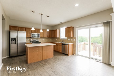 A kitchen with wooden cabinets and a refrigerator.