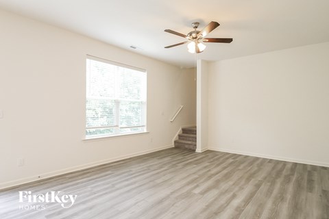 a living room with hardwood floors and a ceiling fan