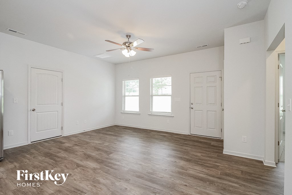 a bedroom with white walls and white doors and a ceiling fan