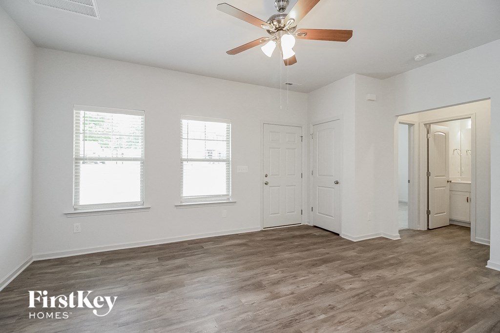 the living room of an empty house with a ceiling fan