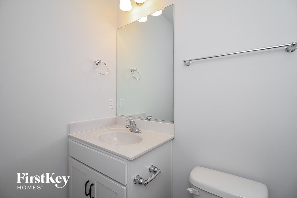 a white bathroom with a sink and a mirror