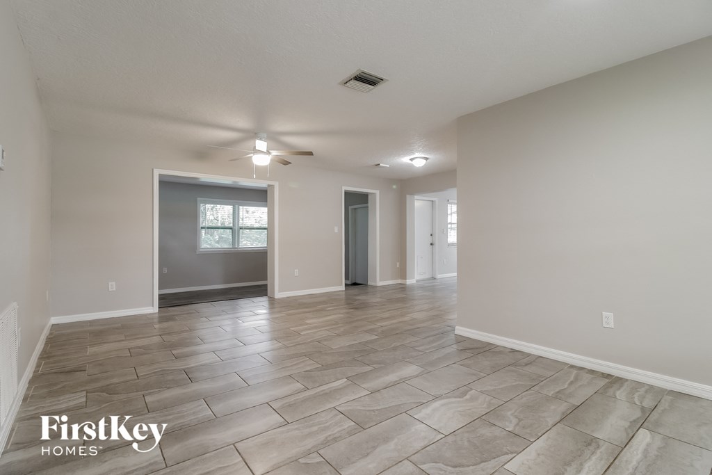 the spacious living room with tile flooring and grey walls