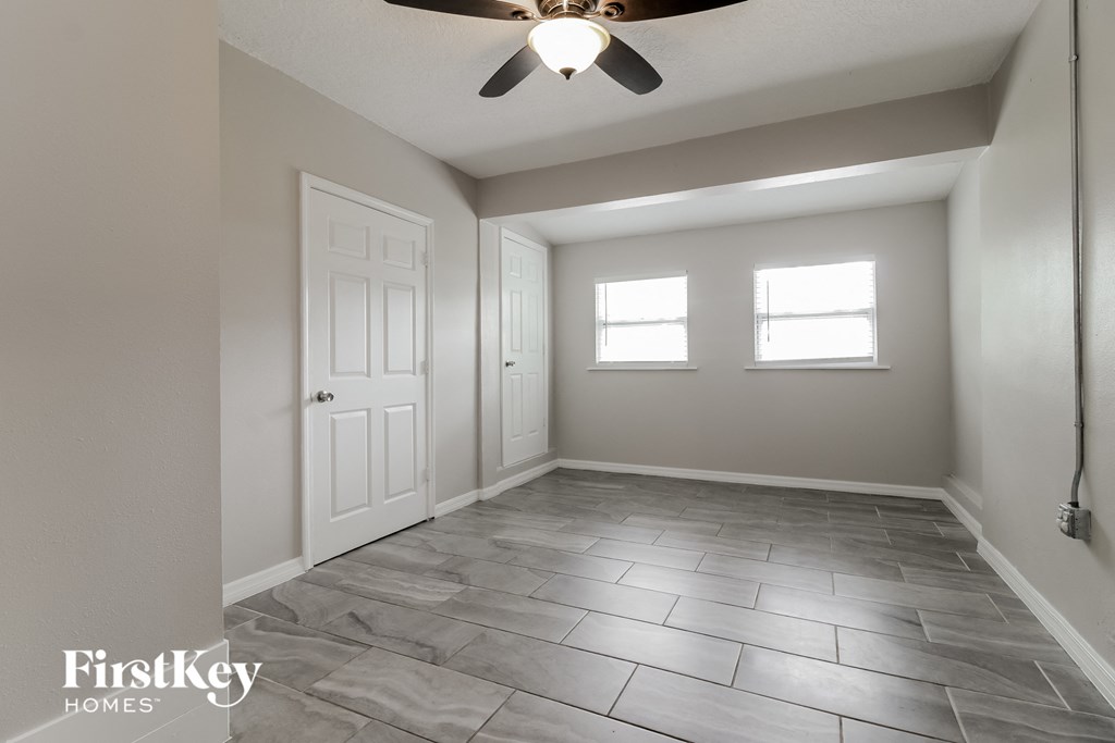 an empty room with a ceiling fan and a window
