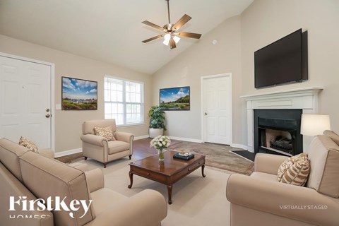 A living room with a fireplace and a television on the wall.