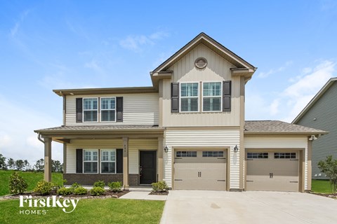 a beige house with two garage doors