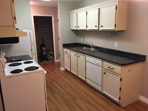 a kitchen with white cabinets and a stove and a sink