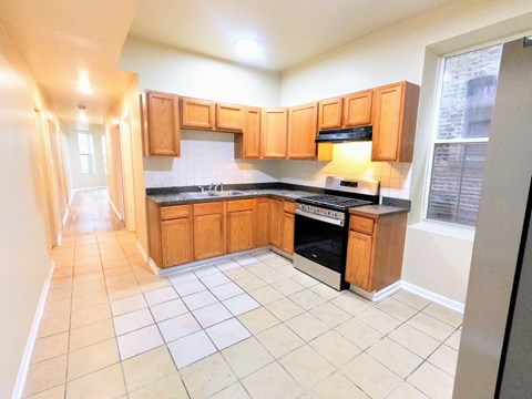 a kitchen with wooden cabinets and a stove and a sink