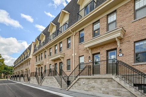 a large brick building with stairs and a street in front