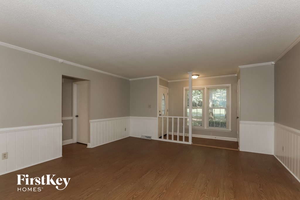 the living room of a house with a hardwood floor and a staircase