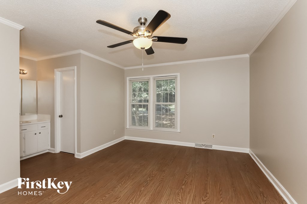 the living room of an empty house with a ceiling fan