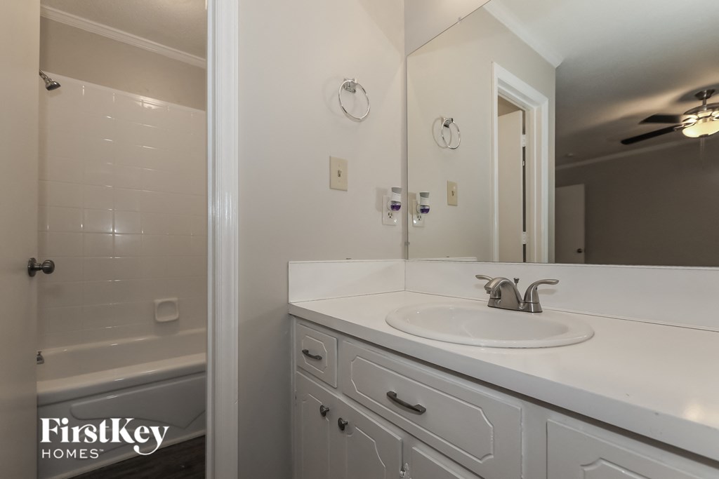 a bathroom with a sink and a shower and a mirror
